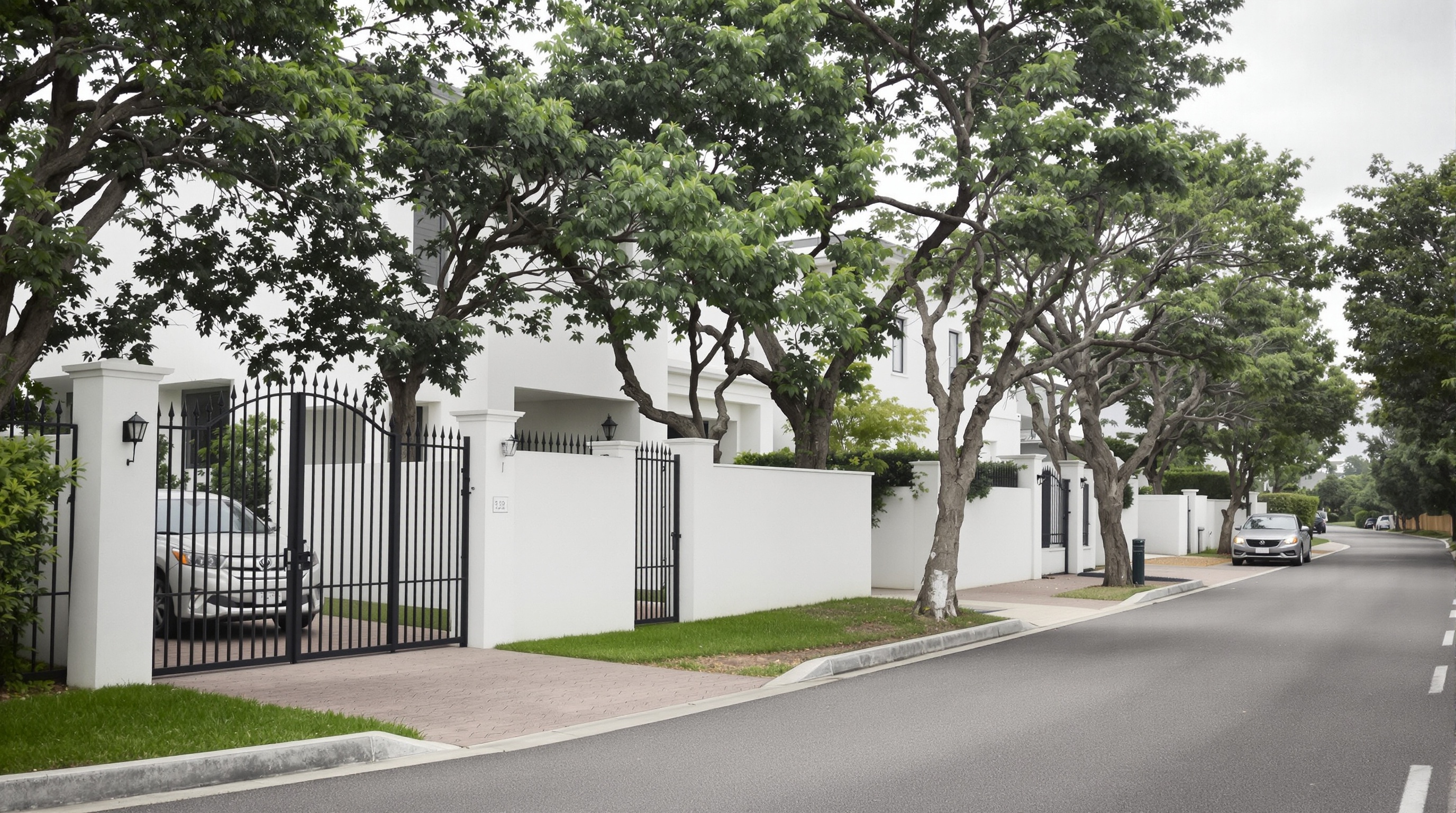 Rua arborizada de residencial consolidado em Alphaville com casas alto padrão e muros de segurança