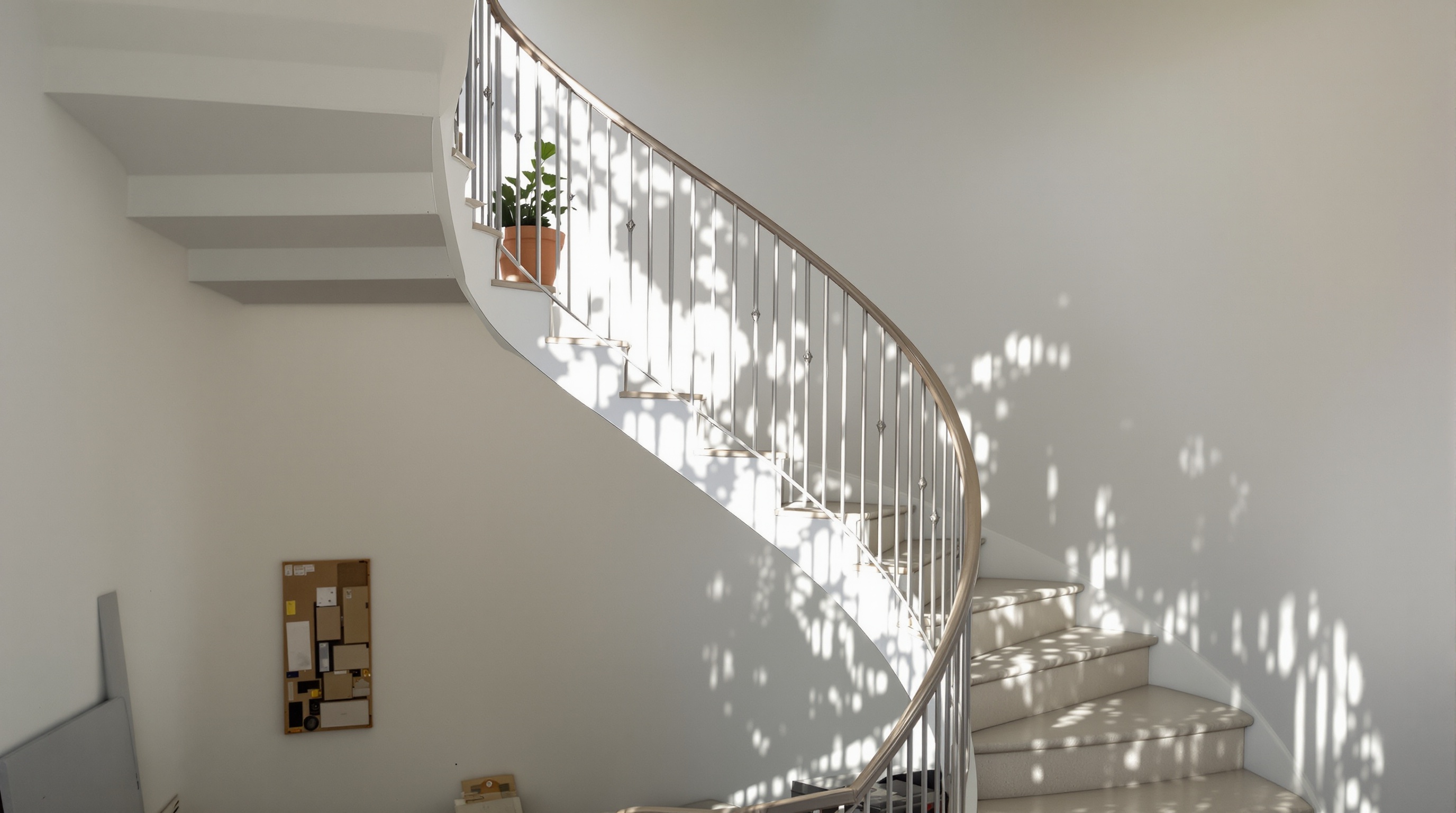 Escada em espiral dentro de sala com pé direito duplo e luz natural