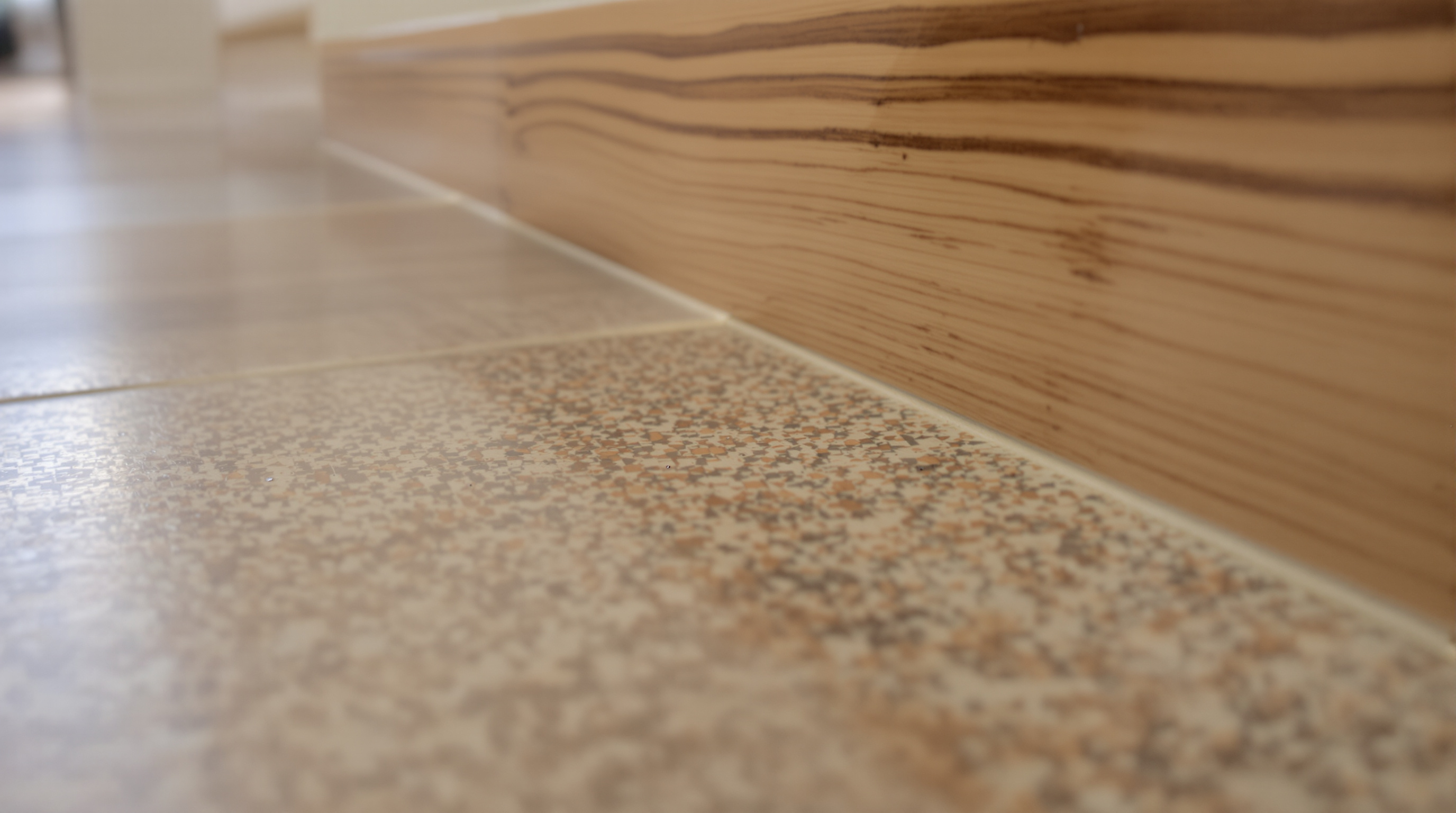 Detalhe de textura em pedra natural e madeira em piso de alto padrão, evidenciando tato e materiais da arquitetura sensorial