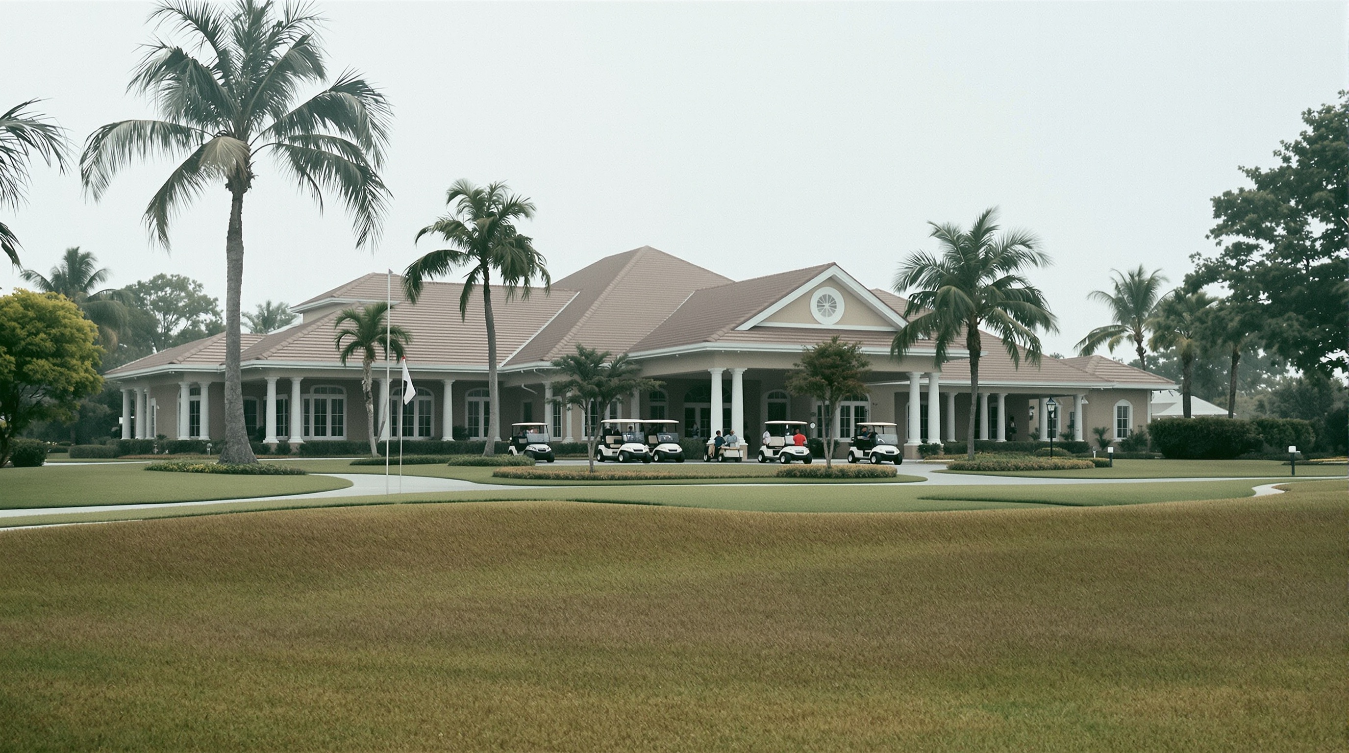 Clubhouse e fairway do Bear's Club, campo de golfe exclusivo em Jupiter, com carrinhos de golfe estacionados